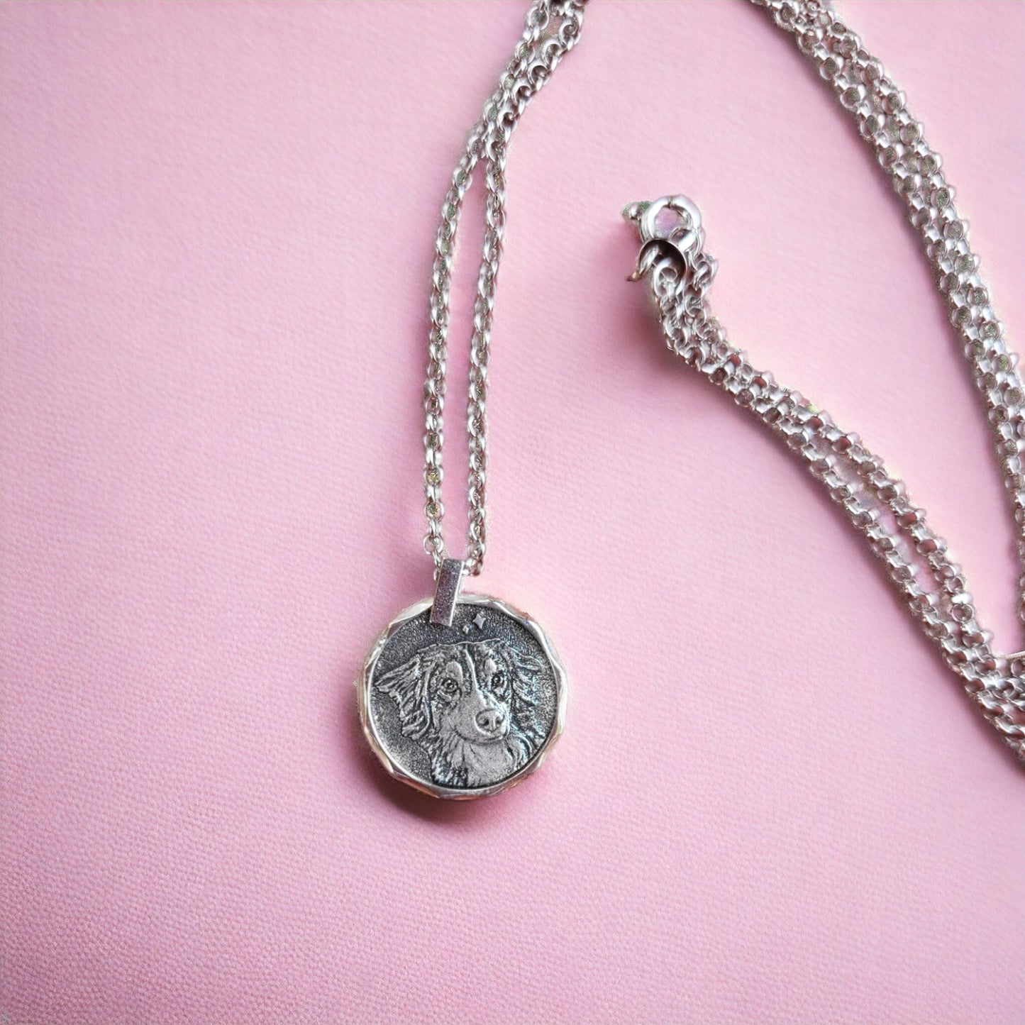 Handcrafted sterling silver coin necklace with a pet portrait on a pink background