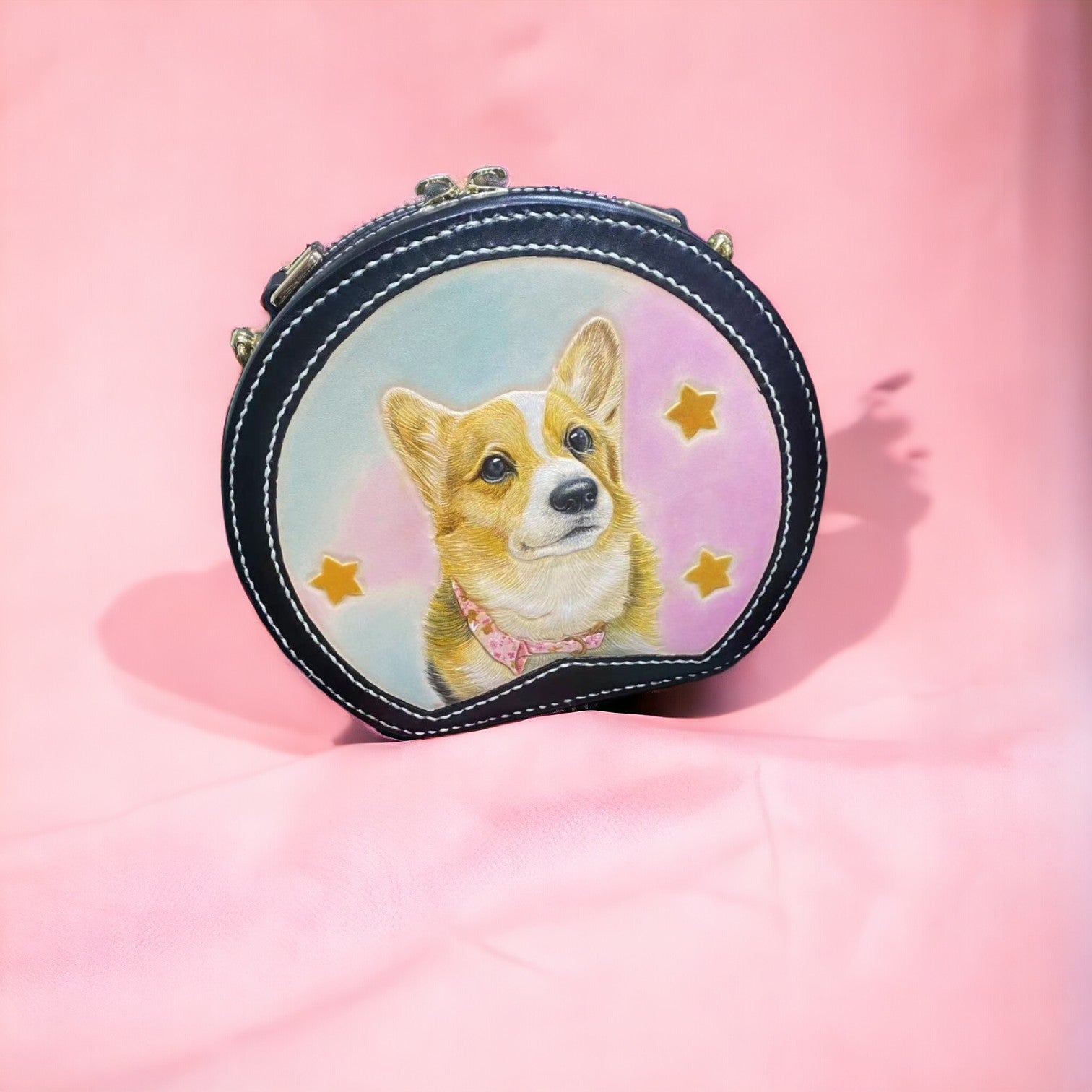 Close-up of a leather handbag featuring a custom dog portrait, front view