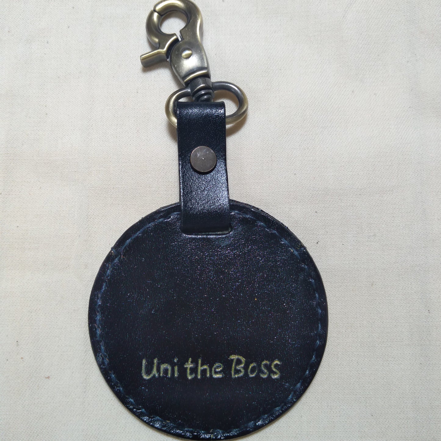 Back view of a custom leather keychain with the inscription 'Uni the Boss'