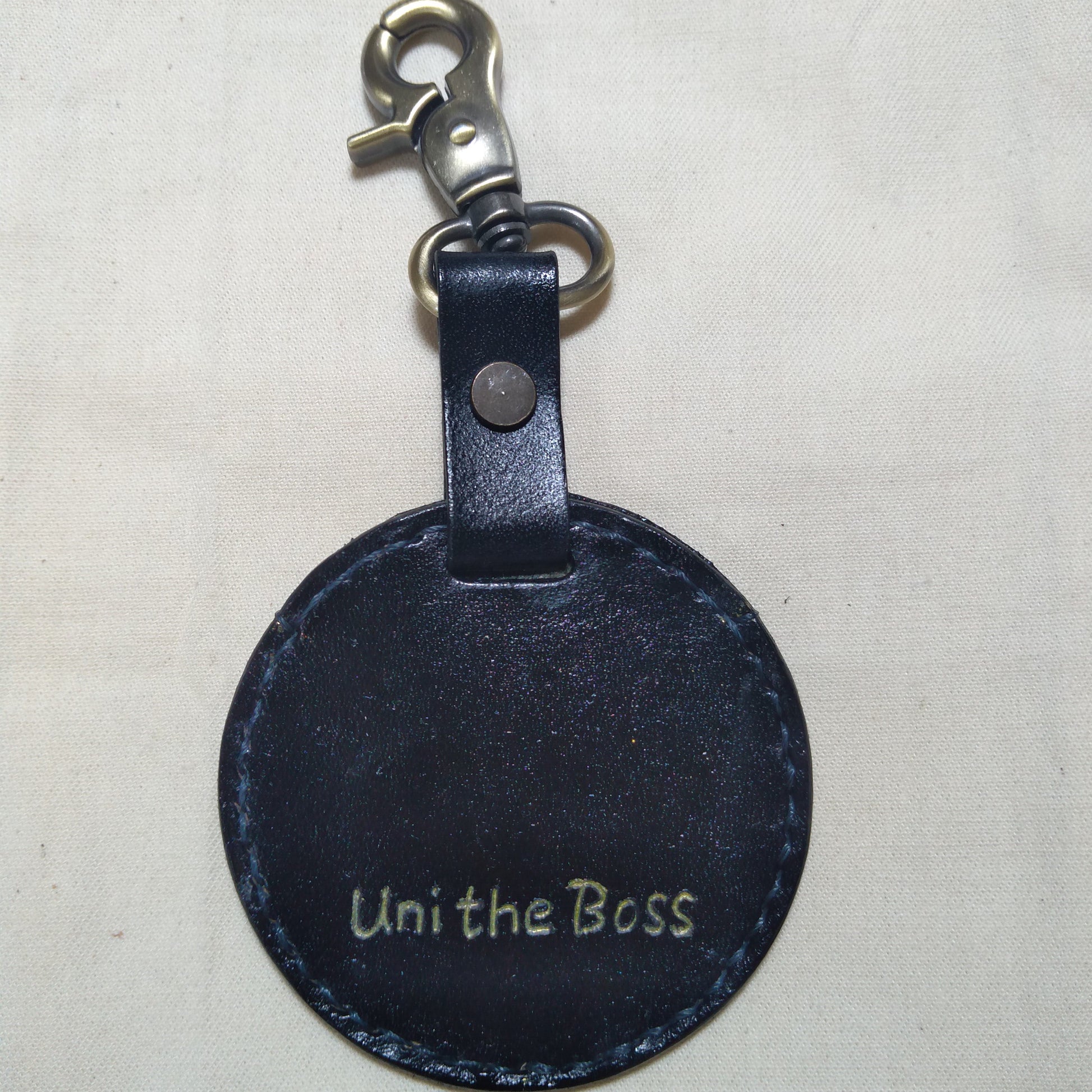 Back view of a custom leather keychain with the inscription 'Uni the Boss'