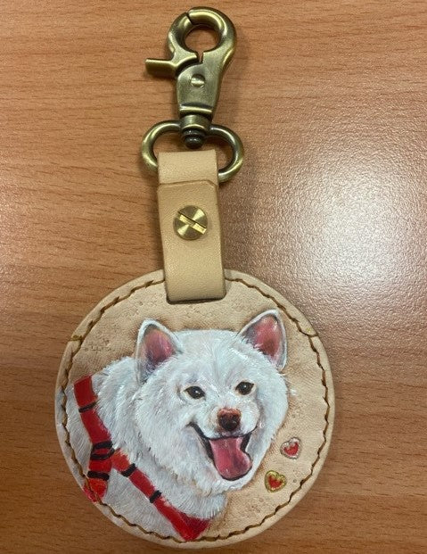 Custom hand-painted leather keychain with a portrait of a tan dog