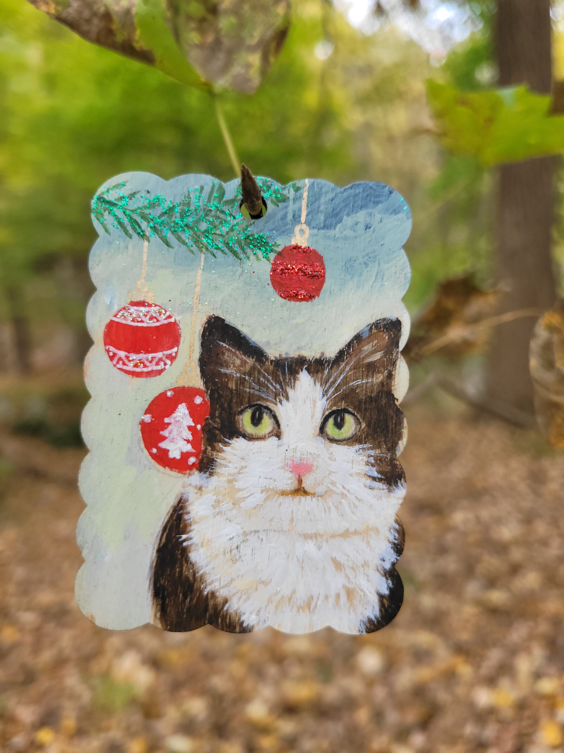 Personalized pet portrait wood tag ornament with a cat portrait and festive decorations.