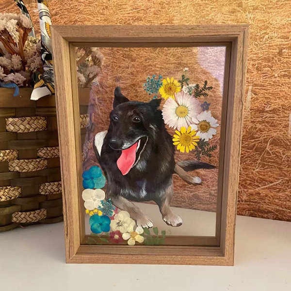 Custom hand-painted black dog portrait on glass with a wooden frame, adorned with colorful flowers.