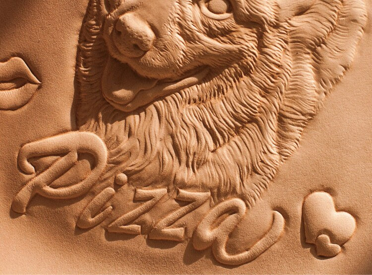 Side view showing the depth and details of the hand-carved leather frame featuring a dog