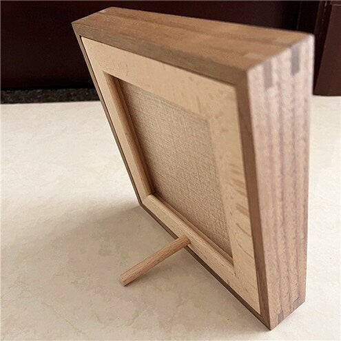 Back view of the custom pet portrait hand-carved leather frame showing the timber frame and stand