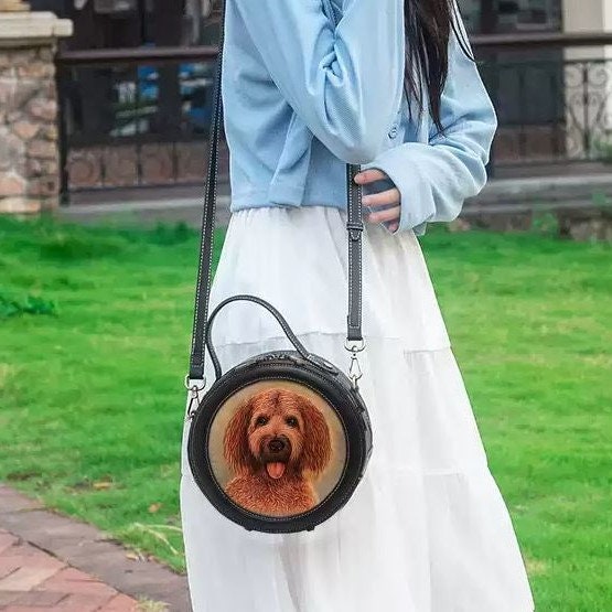 Image of a woman holding a custom dog portrait leather handbag, showcasing its size