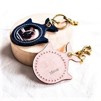 Fish shaped personalized and hand-crafted keychain pet portrait of a cat in blue and pink colors leather.