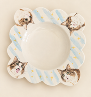 Hand-painted pet portrait plate with blue stripes on a plain backdrop