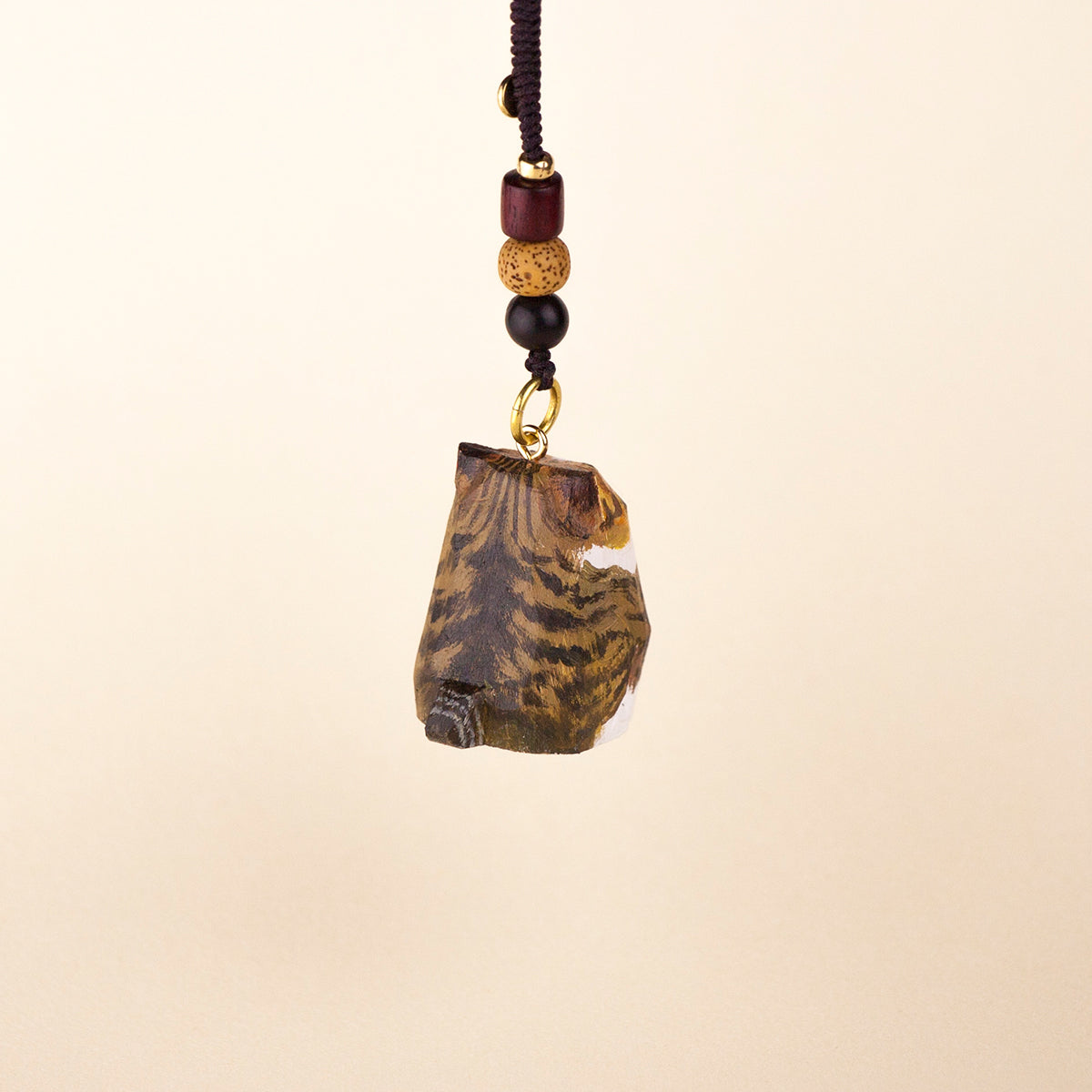 Back view of a hand-painted cat keychain pendant with intricate fur details and wooden bead accents.