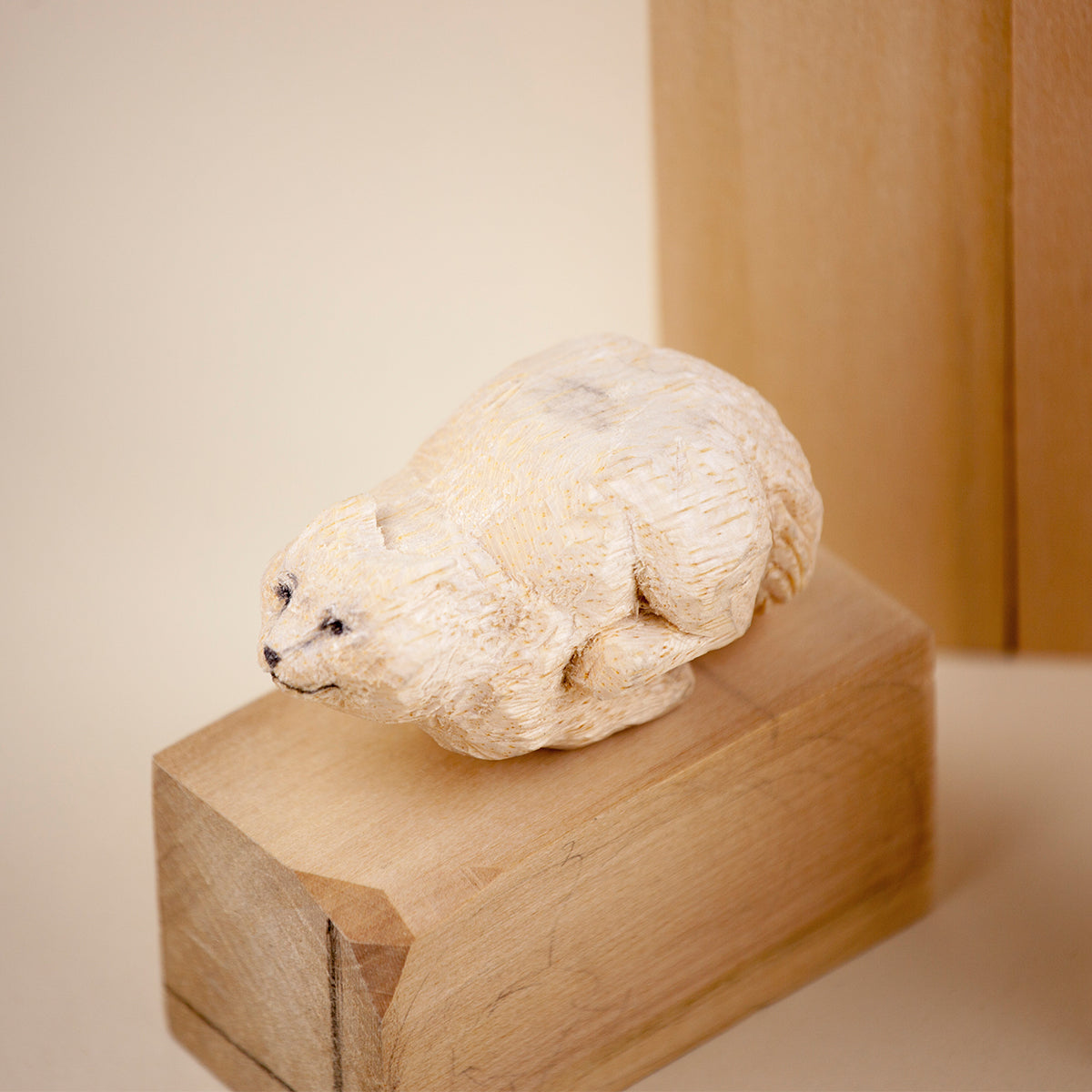 Custom wood carved cat figurine lying down on a wooden block