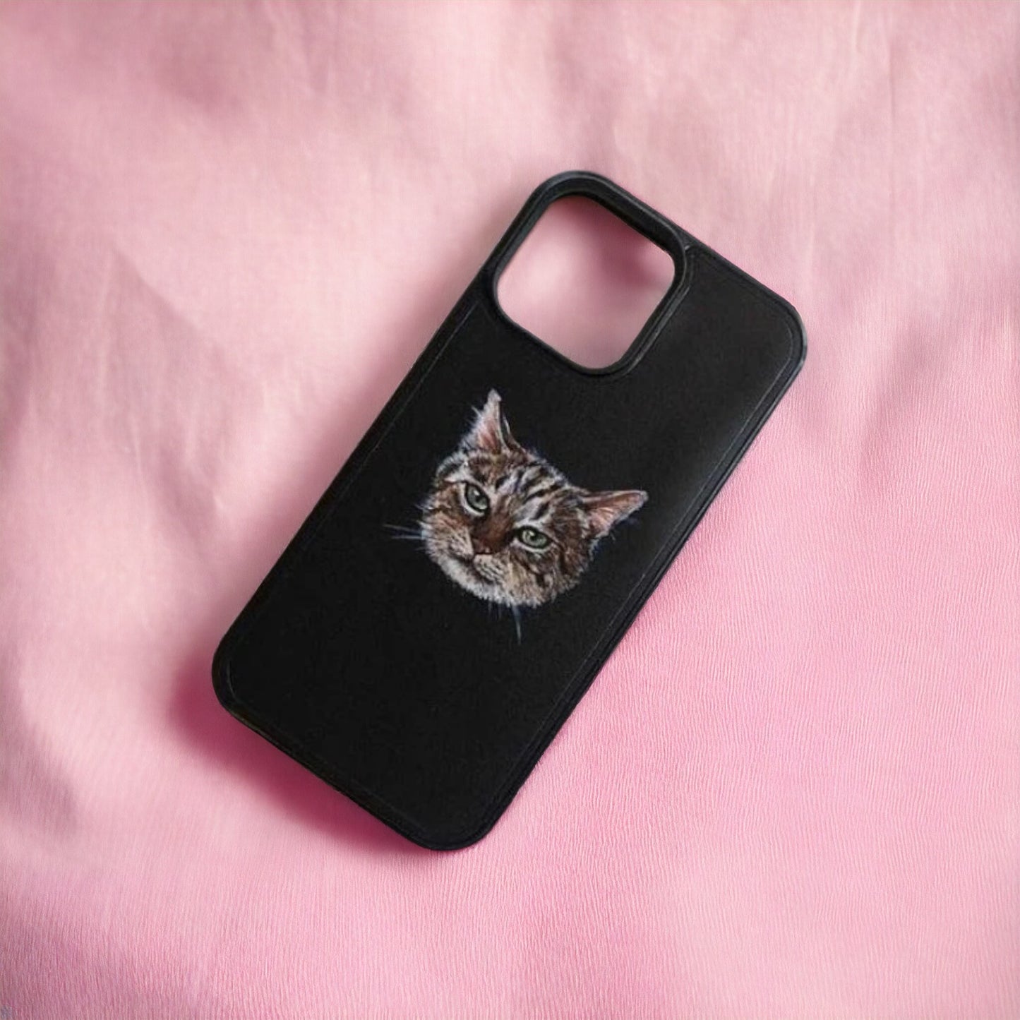 Custom-made phone case with a hand-painted pet portrait on vegan-tanned leather, featuring a detailed image of a cat against a pink background.