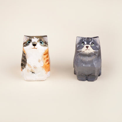 Front view of two handcrafted cat ornaments, hand-painted with unique fur patterns, capturing realistic feline expressions.