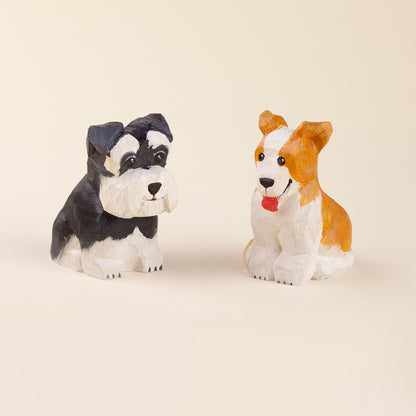 Hand-painted wooden figurines of a black and white dog and a brown and white dog