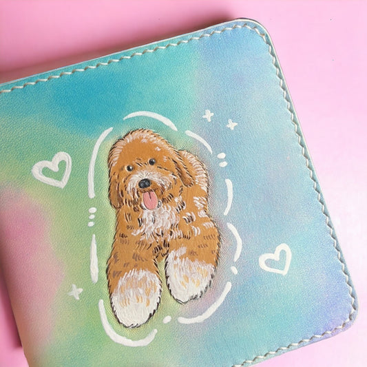 Personalized leather wallet, meticulously hand made, showcasing a hand-painted art portrait of a dog with white and brown fur on a pink background.