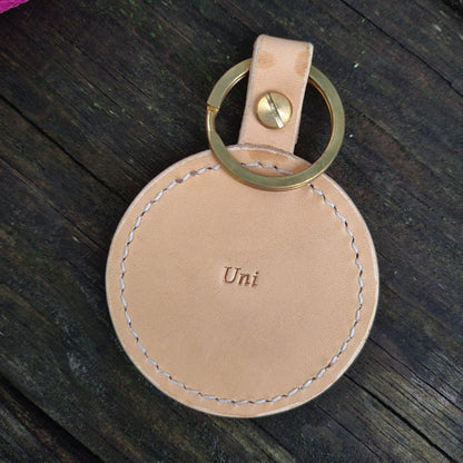 Handpainted leather keychain showing the back side, displaying the natural leather texture and stitching